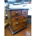 AN ANTIQUE MINIATURE CHEST OF DRAWERS.