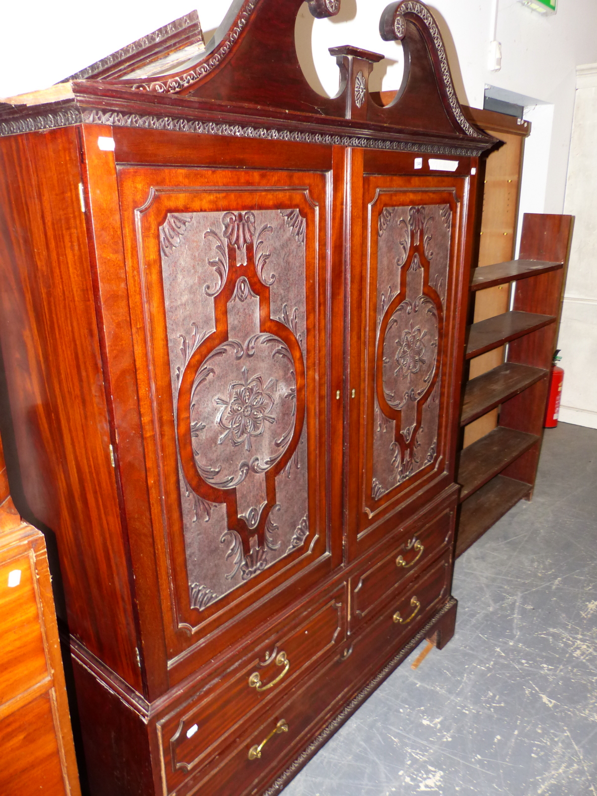 AN EDWARDIAN MAHOGANY DWARF LINEN PRESS WITH BREAK ARCH PEDIMENT