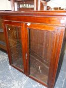 A TWO DOOR GLAZED BOOKCASE.