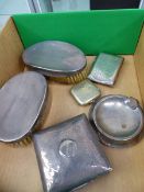 A HALLMARKED SILVER CIGARETTE CASE, A CIGARETTE BOX, AN ASH TRAY, TWO SILVER BACKED BRUSHES AND A