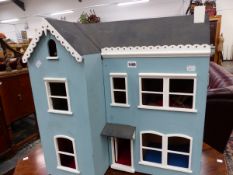 AN ORNAMENTAL SMALL WOODEN VINTAGE DOLLS HOUSE.