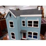 AN ORNAMENTAL SMALL WOODEN VINTAGE DOLLS HOUSE.