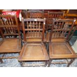 A SET OF FIVE ANTIQUE SPINDLE BACK OAK PANEL SEAT CHAIRS.