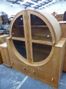 AN ART DECO PALE OAK CIRCULAR DISPLAY CABINET.