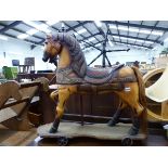 A VINTAGE STYLE PAINTED TOY HORSE ON WHEELS.