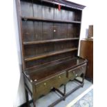 A 19th C. OAK DRESSER, THE ENCLOSED THREE SHELF BACK ON A BASE WITH TWO DRAWERS, A WAVY APRON AND