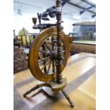 A 19th C. OAK SPINNING WHEEL, A CANDLE HOLDER ABOVE THE SPOKED WHEEL AND TREADLE BOARD BETWEEN THE