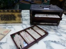 A COMPOSITION MAHJONG SET WITHIN HAMMERED METAL CASE TOGETHER WITH A CHINESE BRASS CYLINDRICAL