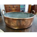 A LATE VICTORIAN COPPER TWO HANDLED OVAL LARGE OVAL PAN. W 58cms.