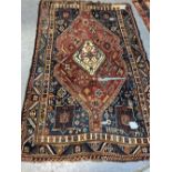 AN ANTIQUE PERSIAN SHIRAZ RUG (LOSSES), 219 x 141cms