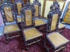 A SET OF SIX OAK CHARLES II STYLE CHAIRS, EACH WITH A CANED BACK WITHIN FOLIATE PIERCING FLANKED