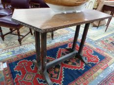 AN ARTS AND CRAFTS OAK TABLE WITH TRIANGULAR NARROW ENDS ABOVE PAIRS OF LEG JOINED ABOVE THE FEET BY