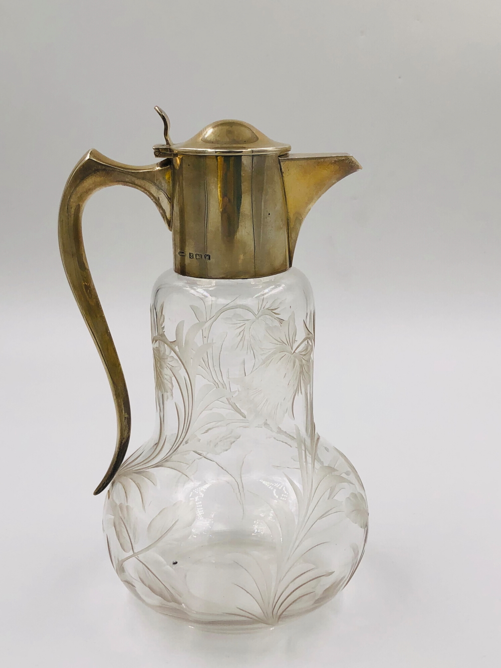 A HALLMARKED SILVER AND ETCHED GLASS CLARET JUG DATED 1921 BIRMINGHAM FOR JOHN GRINSELL AND SONS.