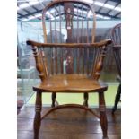 AN ANTIQUE WINDSOR CHAIR WITH TRIPLE PIERCED SPLAT FLANKED BY THREE STICKS, THE SADDLE SEAT ABOVE A