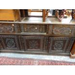 A 19TH CENTURY CARVED OAK DRESSER BASE.