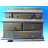 A LATE VICTORIAN OAK MINIATURE DRESSER, THE TOP WITH THREE RECESSED DRAWERS, THE BASE WITH TWO SHORT