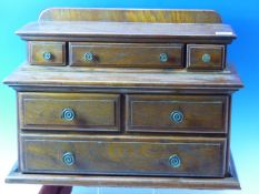 A LATE VICTORIAN OAK MINIATURE DRESSER, THE TOP WITH THREE RECESSED DRAWERS, THE BASE WITH TWO SHORT