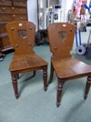 A PAIR OF 19th C. OAK HALL CHAIRS, THE BACKS WITH SHIELD SHAPED PANELS PAINTED WITH FALCON CRESTS,