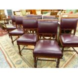 A SET OF EIGHT EDWARDIAN WALNUT LEATHER DINING CHAIRS, THE SQUARED BACKS UPHOLSTERED IN RED ABOVE OP