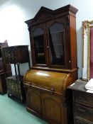 A 19th C. MAHOGANY CYLINDER BUREAU BOOKCASE, TRIANGLES TOPPING THE PEDIMENT, THE GLAZED DOORS AND