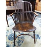 AN ANTIQUE LOW BACKED WINDSOR CHAIR WITH NINE STICK BACK, THE SADDLE SEAT ABOVE A CRINOLINE STRETCHE