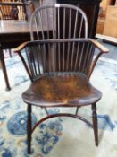AN ANTIQUE LOW BACKED WINDSOR CHAIR WITH NINE STICK BACK, THE SADDLE SEAT ABOVE A CRINOLINE STRETCHE