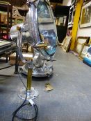 A PAIR OF LARGE VINTAGE CAST AND POLISHED ALUMINIUM FLOODLIGHTS WITH STANDS, THE CIRCULAR FRAME TO