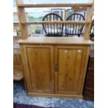 AN ANTIQUE PINE SIDE CABINET WITH RAISED SHELF OVER.
