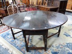 AN 18th C. OAK OVAL DROP FLAP TABLE WITH A DRAWER TO ONE NARROW END, THE BALUSTER LEGS JOINED BY