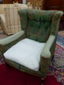 A LATE VICTORIAN ARTS AND CRAFTS UPHOLSTERED WING ARMCHAIR.