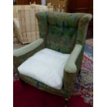 A LATE VICTORIAN ARTS AND CRAFTS UPHOLSTERED WING ARMCHAIR.