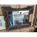 AN ANTIQUE CARVED CHINESE EXPORT FRAME (WITH LOSSES) NOW WITH A MIRROR PLATE OVERALL 50 X 62cms