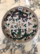 A CHINESE CRACKLEWARE DISH PAINTED IN FAMILLE VERTE ENAMELS WITH A GREEN AND AN AUBERGINE DRAGON