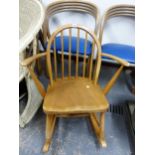 AN ERCOL HOOP BACKED ROCKING CHAIR, THE SIX STICK BACK ABOVE AND SADDLE SEAT FLANKED BY CURVED ARMS