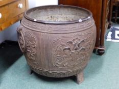 A LARGE CHINESE IRON CAULDRON CAST WITH FOUR PANELS OF FLOWERING LOTUS ABOUT THE RING HANDLED SIDES