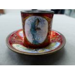 A CONTINENTAL RED ENAMEL ART NOUVEAU CUP AND SAUCER WITH DESIGNS IN THE MANNER OF ALPHONCE MUCHA