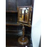 A GEORGE III MAHOGANY FRAMED RECTANGULAR SHAVING MIRROR ADJUSTABLE ON A COLUMN AND LEAD WEIGHTED