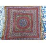 A KIRMAN RED GROUND SHAWL SEWN WITH BANDS OF BUDS, FOLIAGE AND FLOWERS ENCLOSING THE CENTRAL