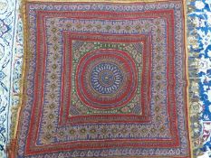 A KIRMAN RED GROUND SHAWL SEWN WITH BANDS OF BUDS, FOLIAGE AND FLOWERS ENCLOSING THE CENTRAL