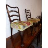 A PAIR OF GEORGE III MAHOGANY LADDER BACKED CHAIRS WITH FLORAL NEEDLE WORKED SEATS, CARVED WITH