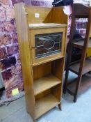 AN ARTS AND CRAFTS CHEQUER LINE INLAID OAK FOUR SHELF BOOK CASE, A LEADED GLASS DOOR OVER AN UPPER