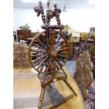 A TURNED OAK SPINNING WHEEL, THE SPOKED WHEEL SUPPORTED ON A SHAPED PLINTH WITH THREE TURNED LEGS. H