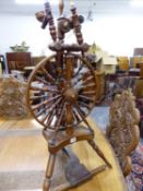 A TURNED OAK SPINNING WHEEL, THE SPOKED WHEEL SUPPORTED ON A SHAPED PLINTH WITH THREE TURNED LEGS. H