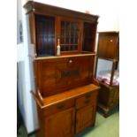 AN ARTS AND CRAFTS MAHOGANY WRITING CABINET WITH SHELVES FLANKING A GLAZED CUPBOARD ABOVE THE FALL