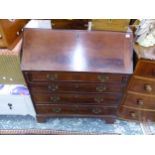 A GEORGE III MAHOGANY WRITING BUREAU WITH WELL FITTED STEPPED INTERIOR OVER FOUR DRAWERS ON