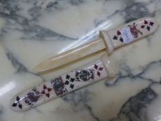 A BONE PAPER KNIFE AND SCABBARD DECORATED WITH PLAYING CARDS AND THEIR SUITS. W 27cms.