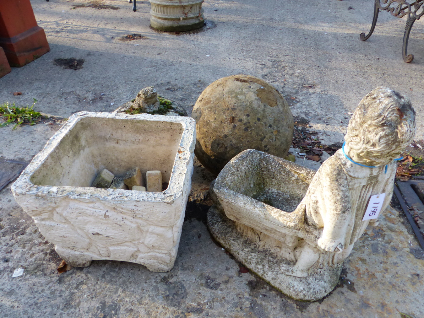 A STONE BALL AND TWO GARDEN ORNAMENTS, PLANTERS ETC