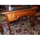 A GEORGE III OAK LOWBOY WITH THREE DRAWERS ABOVE THE WAVY APRON AND THE TAPERING SQUARE LEGS. W 90.5