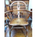 AN ANTIQUE OAK AND ELM WINDSOR CHAIR, THE TRIPLE PIERCED SPLAT FLANKED BY THREE STICKS, THE SADDLE
