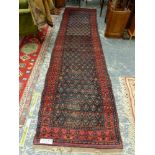 AN ANTIQUE PERSIAN TRIBAL RUNNER, 446 x 105cms